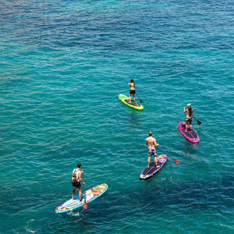 a group of people standing on top of their paddle boards