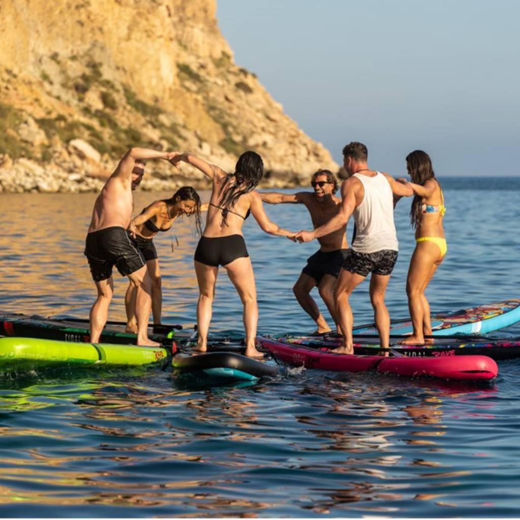 group of people standing on top of their paddle boards